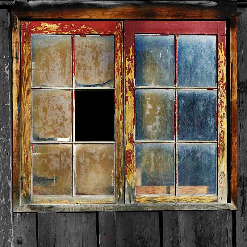 A distressed and broken window with red and orange peeling paint which needs to be fixed